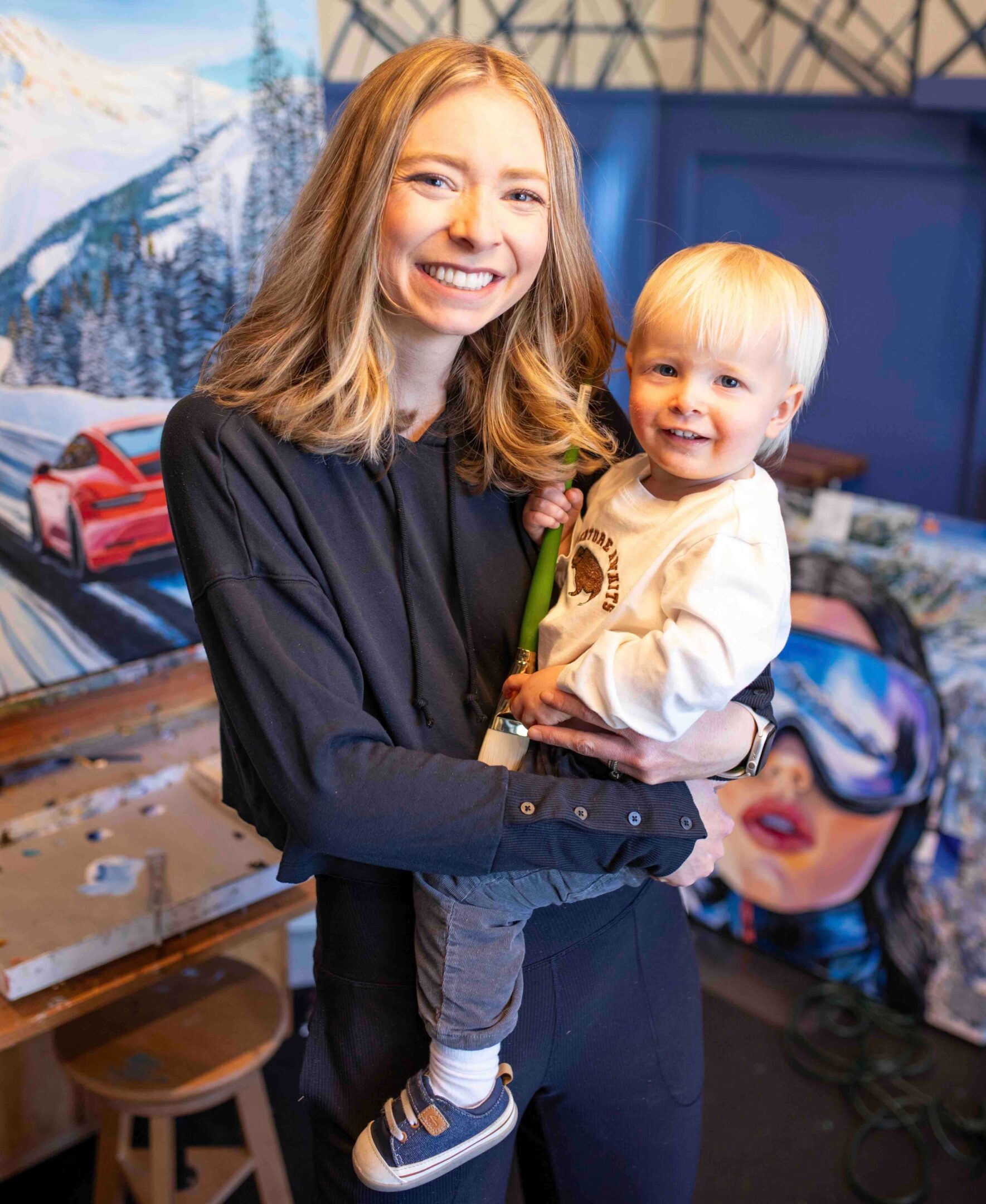 Happy duo with paintings in background